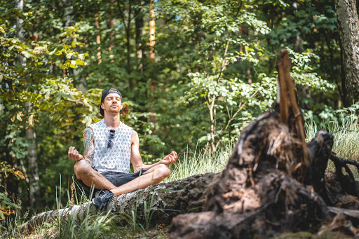 man meditating in forest